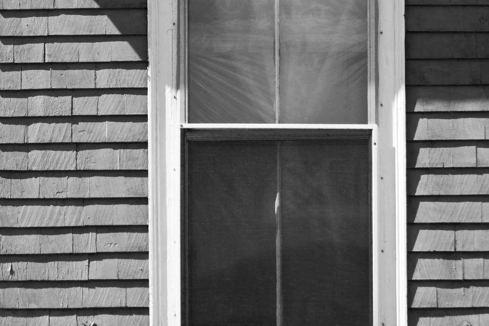 Shingle siding and painted window trim on a house exterior