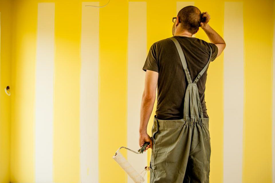 A painter rolling a fresh coat onto an interior wall